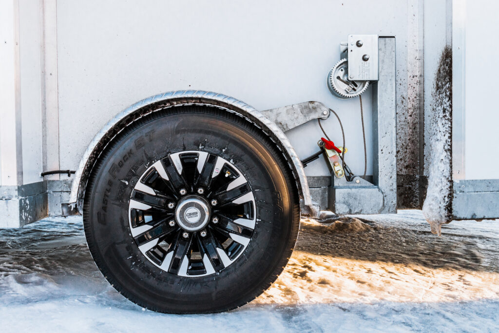 a close-up image of a rubber wheel on a hydraulic system of a fish house camper