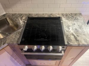 A kitchen's stovetop and sink in a Nordic Lodge fish house