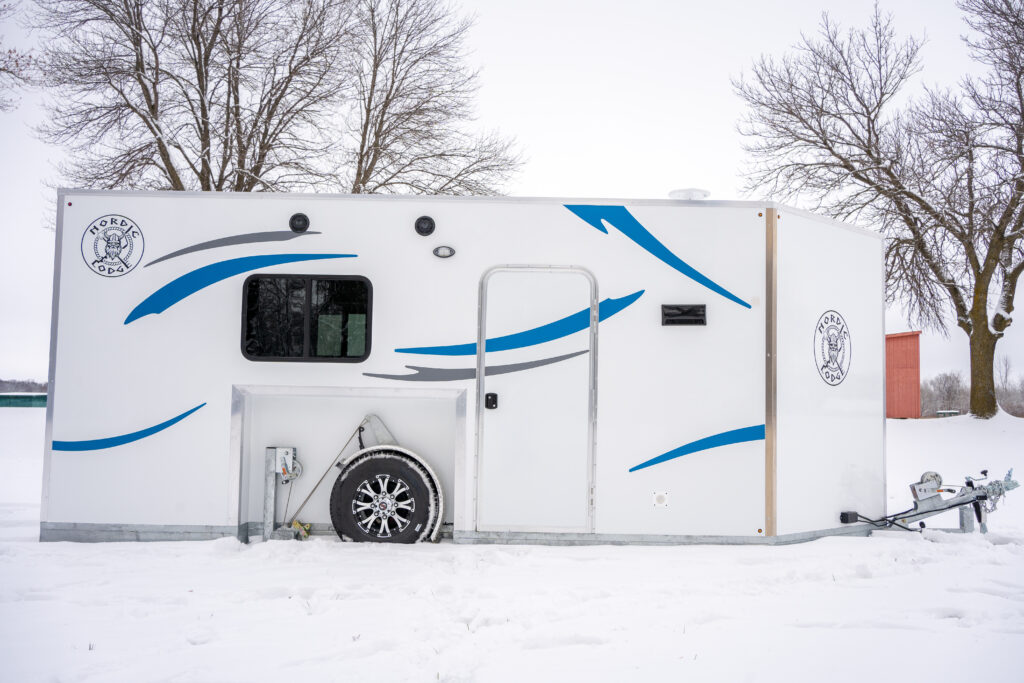 Exterior of white Fish House Camper with blue and grey markings
