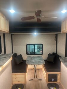fish house's interior of a dining table with two black love seats on both sides.