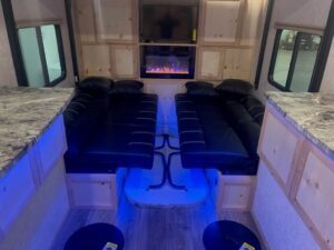 RV interior light up with blue light. Living area with a fire place and a TV