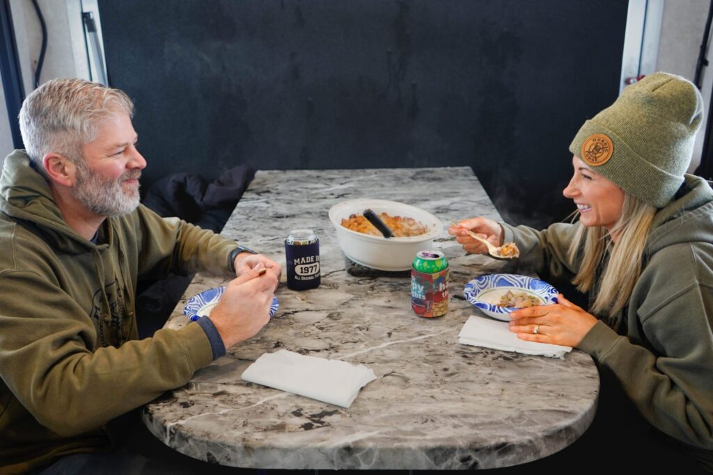 Two people eating lunch in a Nordic Lodge ice house.